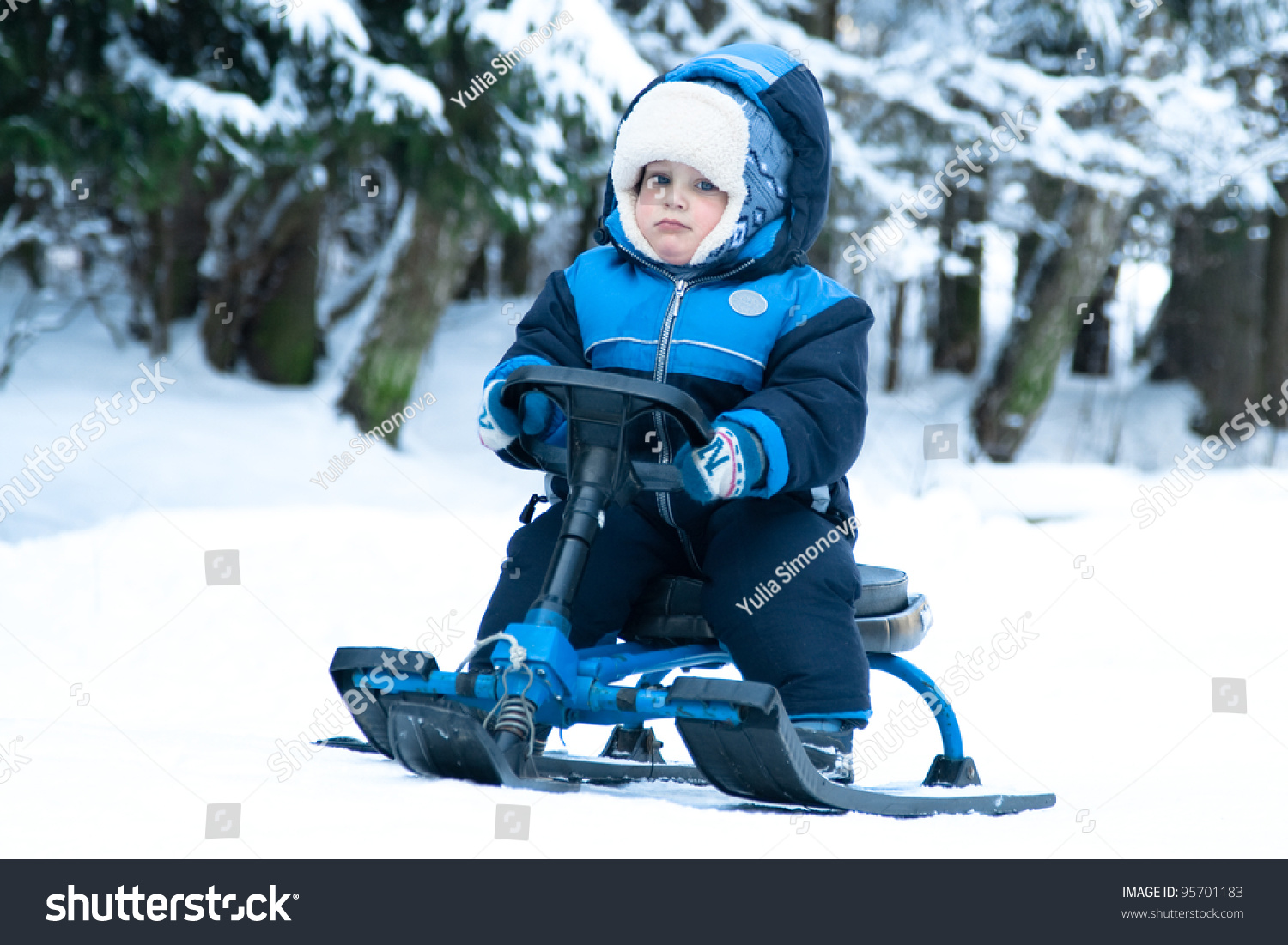 stock-photo-little-boy-riding-snowmobile-in-forest-95701183.jpg